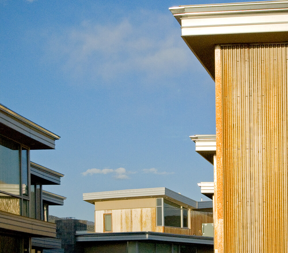 Rooflines and clerestory windows of the green-built homes at El Cerrito against a blue sky