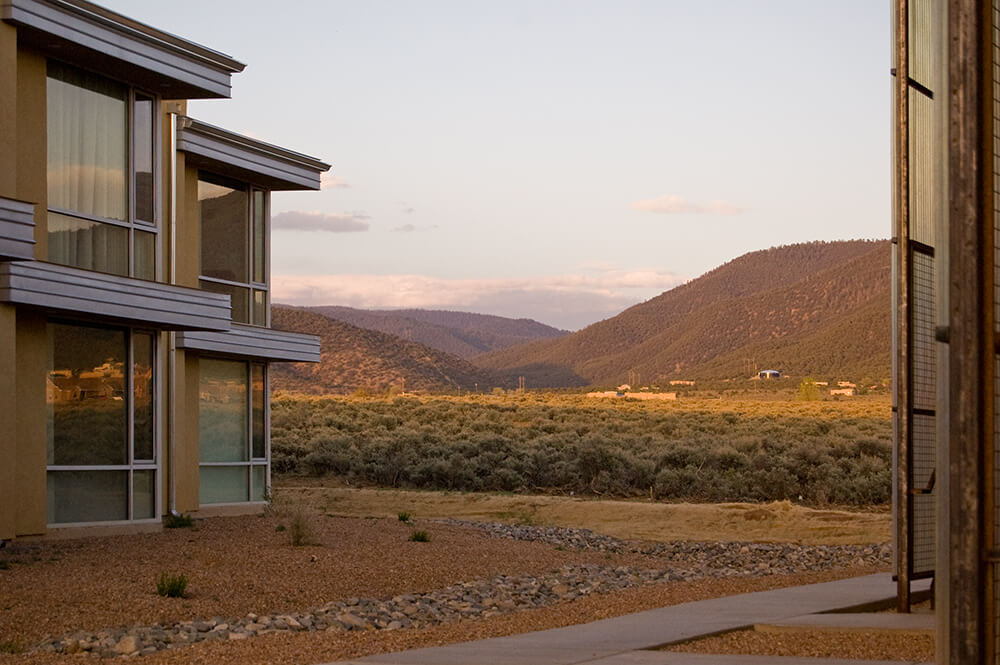 Evening light on apartment homes at El Cerrito with sagebrush flats and forested foothills stretching south