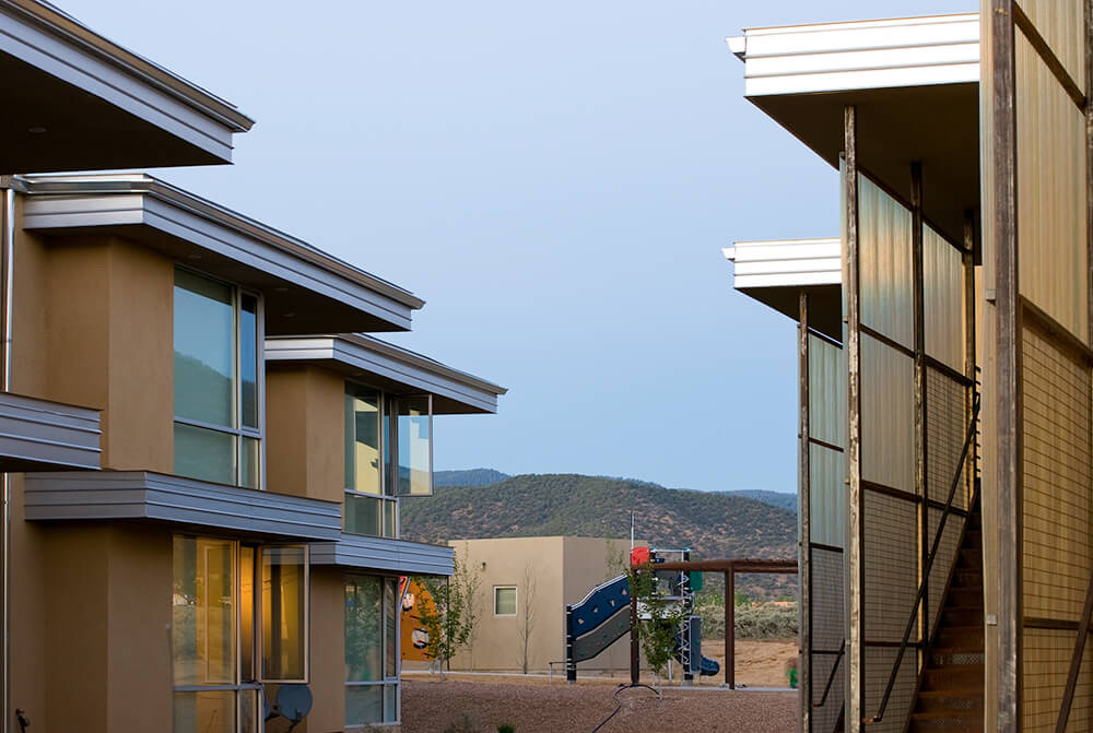 View between buildings at El Cerrito toward the play area and the hills south of Taos