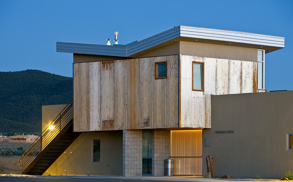 The El Cerrito community center at dusk, its recycled-steel cladding glowing under the entry lights